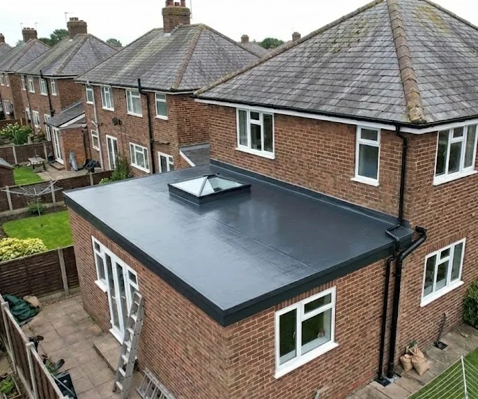 New GRP fibreglass flat roof with a rooflight on a rear extension, with new black guttering