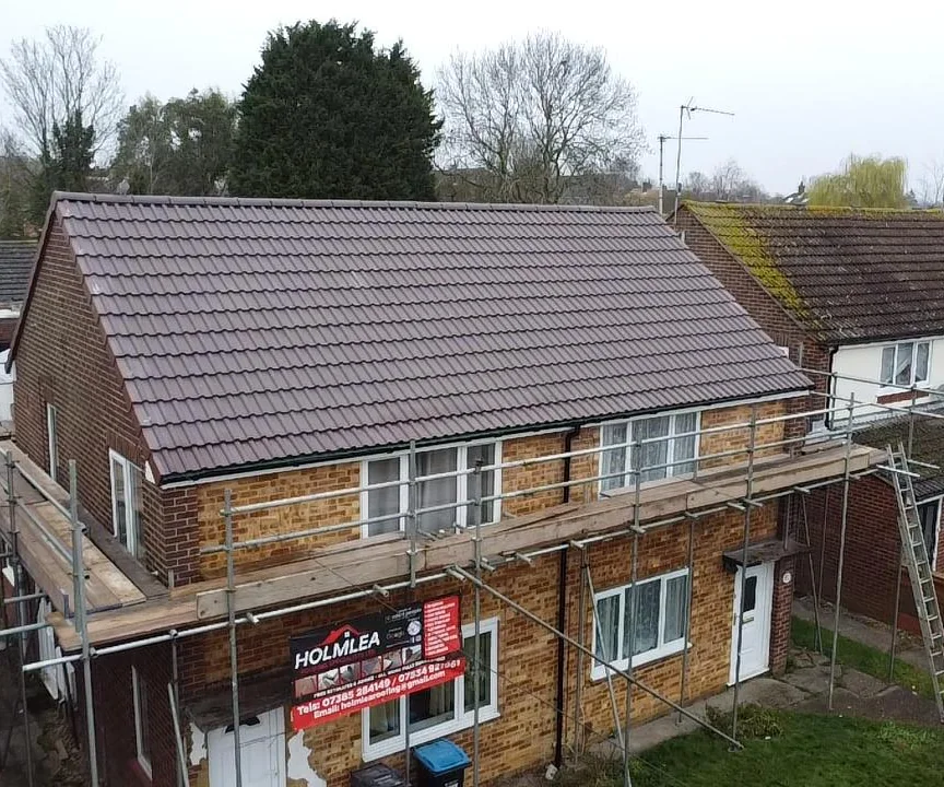 Aerial view of a new brown concrete tile roof on a semi-detached house in Hertfordshire, scaffolded by Holmlea Roofing