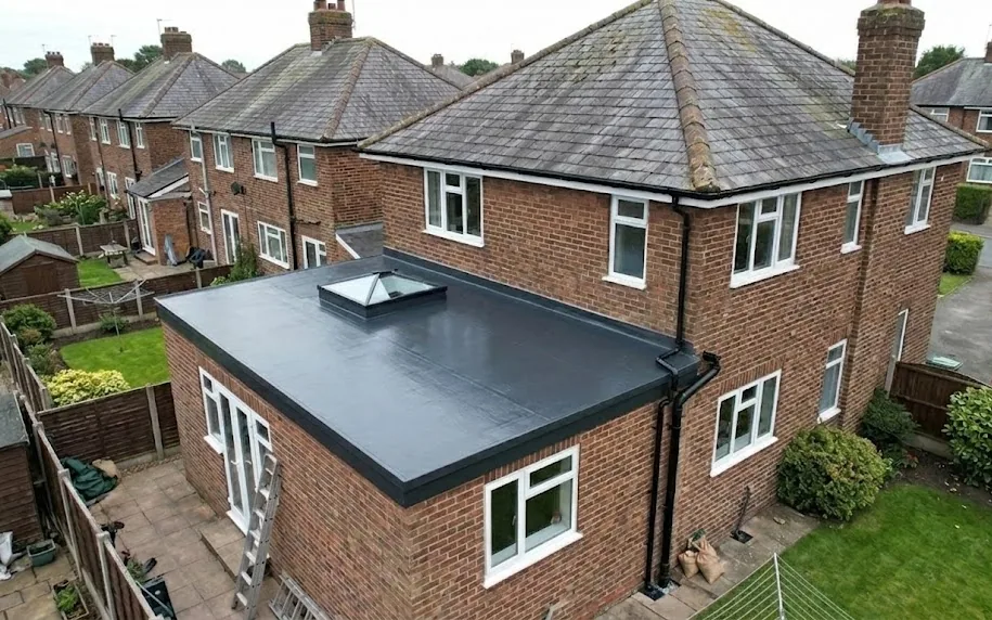 New GRP fibreglass flat roof with a rooflight on a rear extension, new black guttering fitted