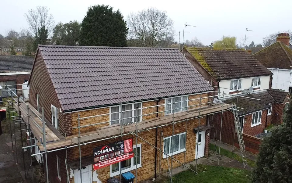 Full re-roof in brown concrete tile on a semi-detached house, aerial view with the Holmlea scaffold banner
