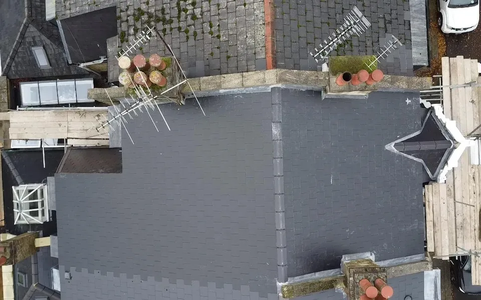 Top-down view of a new slate roof and a new flat roof on the rear extension beneath it