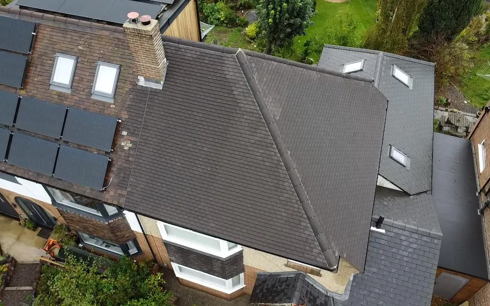 Drone view of a brown tile roof with two Velux roof windows and a brick chimney stack
